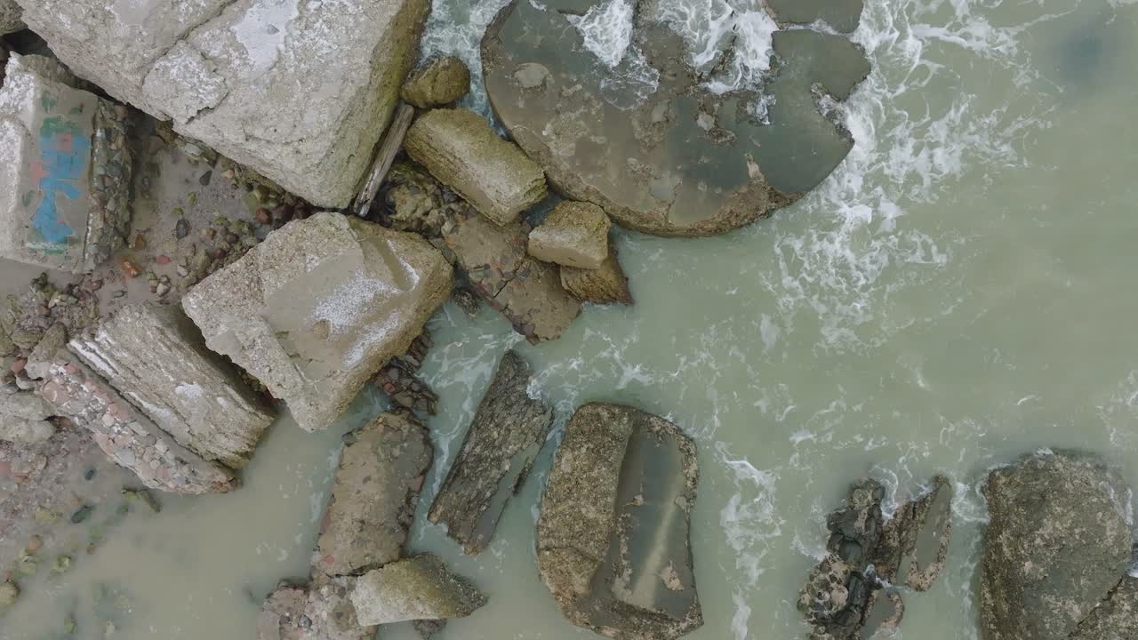 Vista aerea a volo d'uccello di edifici fortificati costieri abbandonati presso i Forti Settentrionali di Karosta sulla spiaggia del Mar Baltico, giornata invernale coperta, ampia ripresa drone statica