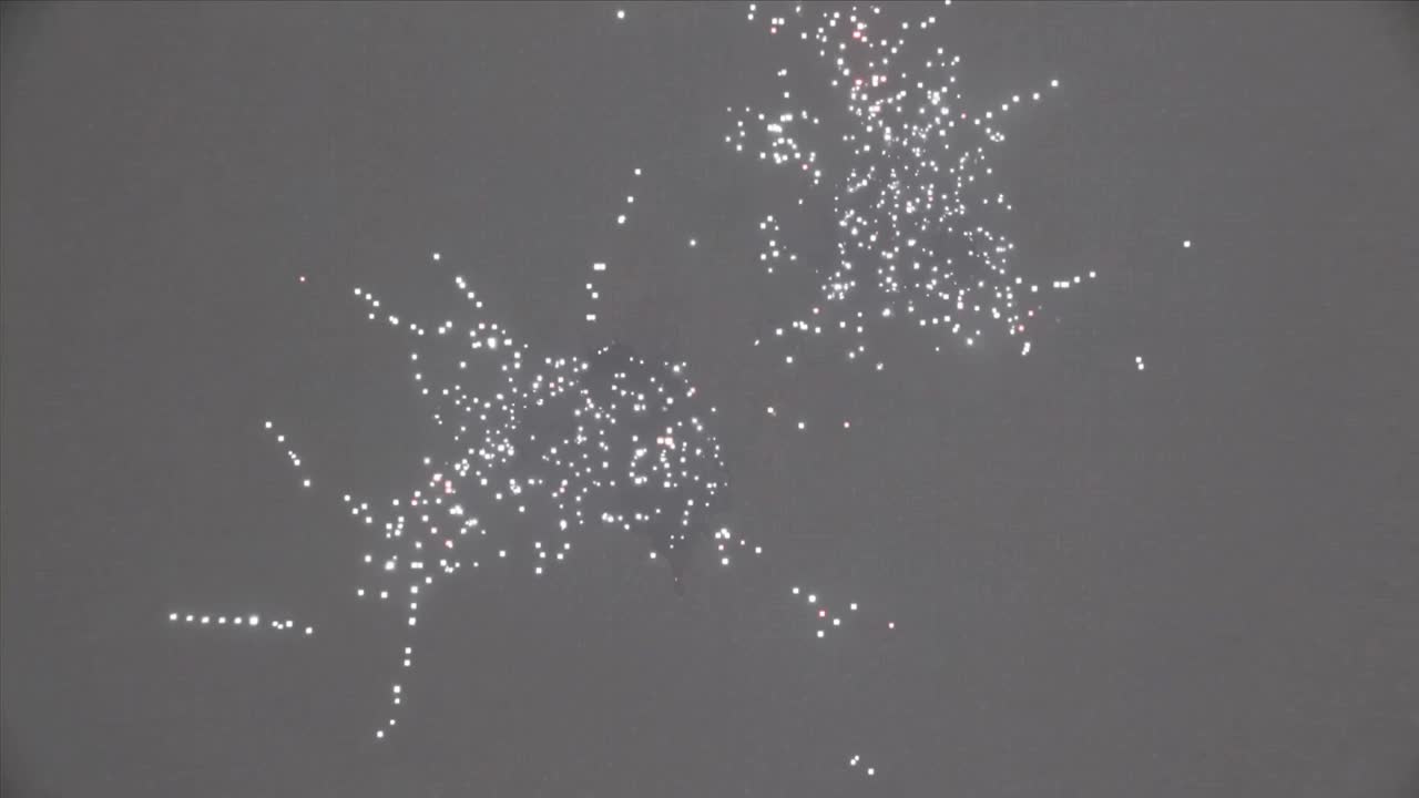 Evoluzione di cluster di particelle che spostano il bianco in nuclei e filamenti rossi su grigio, simulando fuochi d'artificio