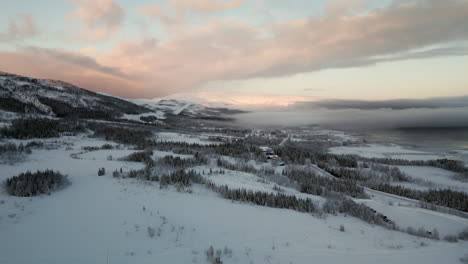 Aerial-over-pristine-arctic-winter-wonderland-at-sunset---snowy-Norway-landscape