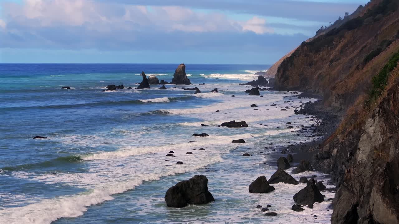 Shoreline Pacific Coastal Highway 1 DeHaven Westport Fort Bragg aerial drone California rugged Coastline blue sky surf waves crashing boulder rocks mountain side clouds sun Pacific Ocean static motion
