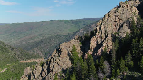 Aerial-Drone-over-a-Colorado-Rocky-Mountain-Peak-revealing-the-Forest-and-Mountain-Range-behind