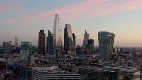 Slow-dolly-forward-aerial-drone-shot-of-City-of-London-skyscraper-buildings-beautiful-sunrise