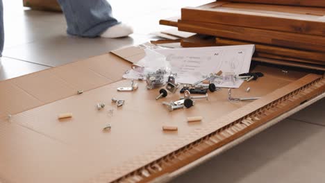 a sequence showing furniture assembly with scattered hardware on a wooden surface, captured in natural lighting