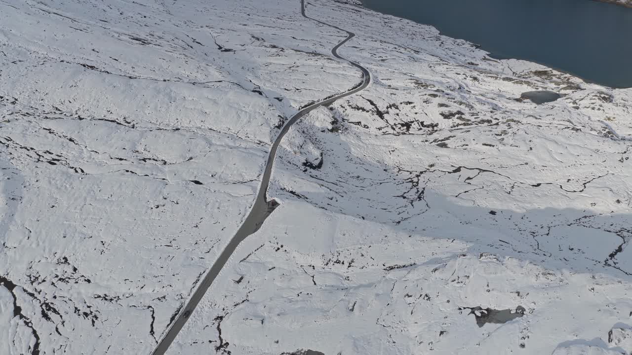Aerial of road snaking through frozen peaks, Norway winter scene