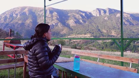 Hispanic-woman-enjoys-hot-coffee-on-crisp-morning-in-Armenia-mountains