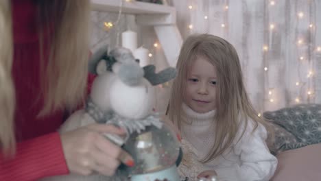 young-woman-plays-with-toy-sheep-and-little-girl-laughs