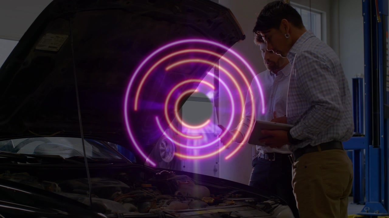 Abstract neon circle over caucasian auto mechanic discussing about car with coworker in repair shop