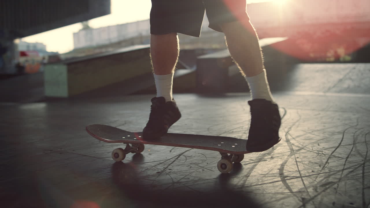 joven patinador realizando un truco de salto en patineta en el parque de patinaje. piernas en zapatillas de deporte