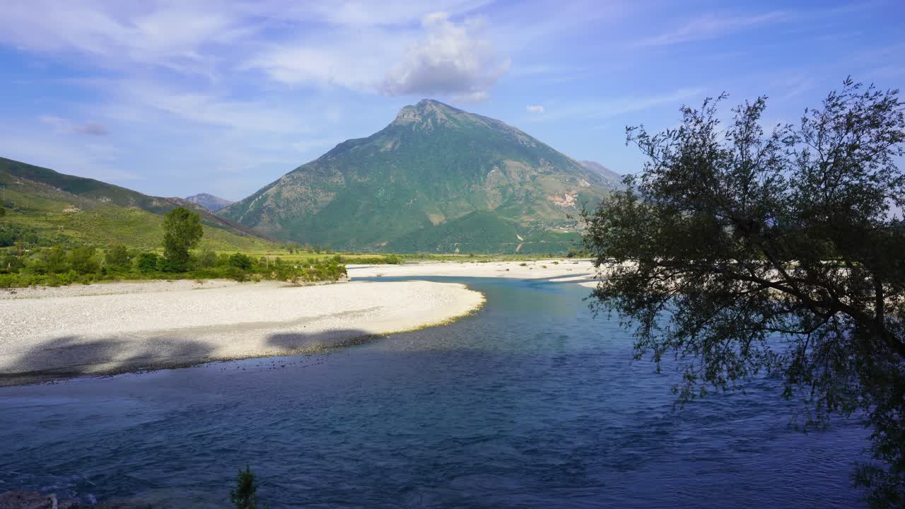 강이 흐르는 자갈 둑, vjosa의 산을 배경으로 한 아름다운 풍경