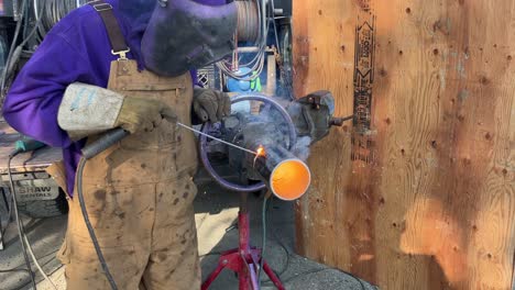 close-up shot of a welder in the zone working on a metal pipe