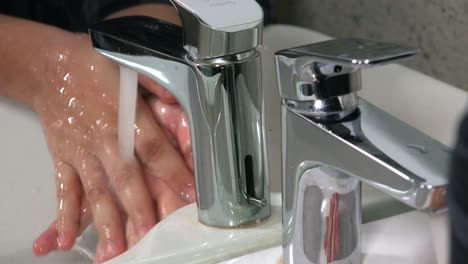 close shot of female washing hands in the sink