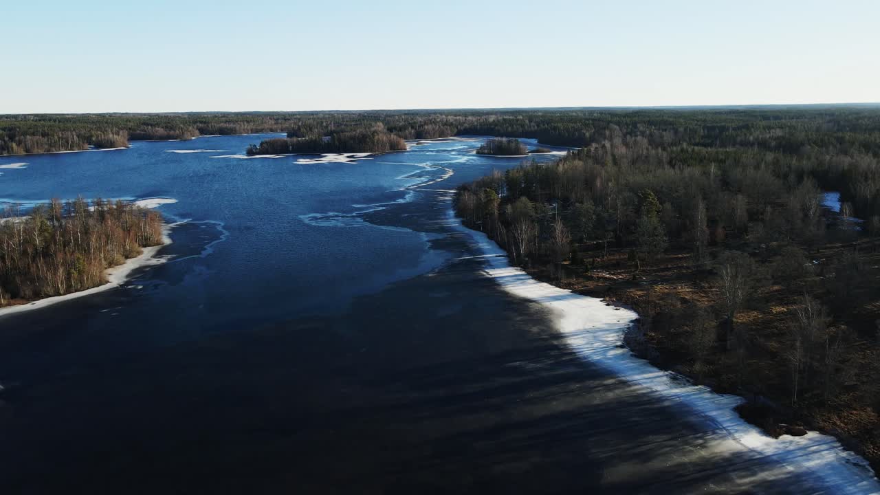 Korkea nosturikuva kauniista järvestä talvella Ruotsin maaseudulla aurinkoisena päivänä.
