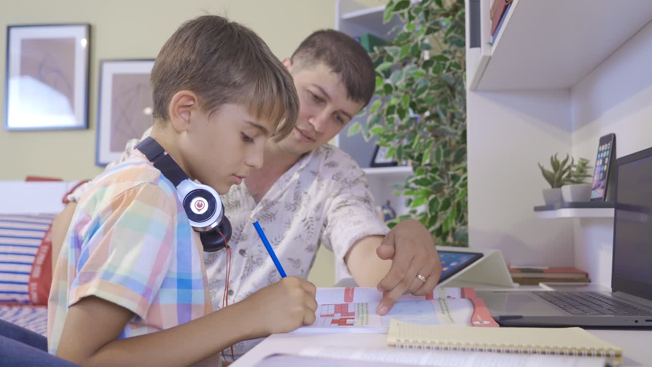 el padre ayuda a su hijo con sus lecciones.