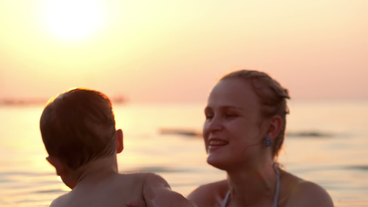 어머니와 아들은 바다에서 수영합니다.