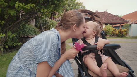 mother playing with toddler in stroller