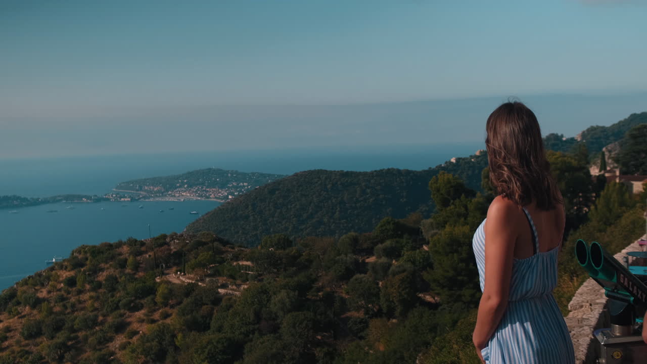 Slow motion close up of pretty brunette woman enjoying beautiful ocean landscape during sunny day in France