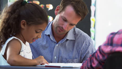 maestro y joven estudiante mirando el cuaderno en clase