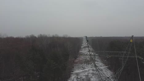 Panning-drone-video-of-power-lines-in-a-snowy-forest