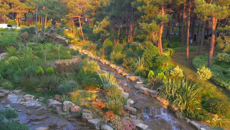 parque al atardecer con cascada y jardines