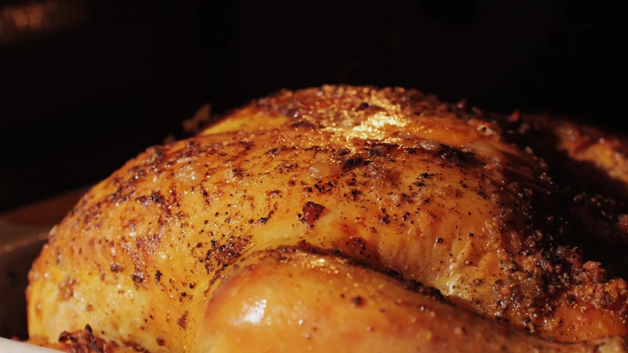 Primo piano di pollo arrosto dorato in cottura nel forno