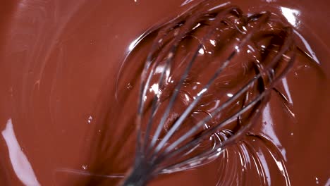 whisk stirring rich, melted chocolate in bowl