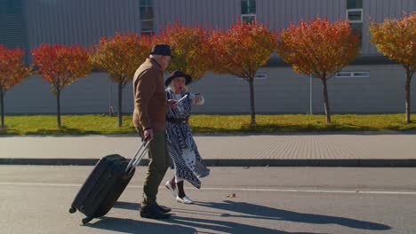 elderly pensioner tourists grandmother grandfather being late running with luggage to airport hall