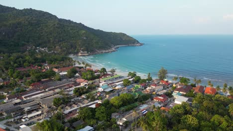 Drone-flight-over-city-on-Thai-Island-with-stunning-beach-and-ocean