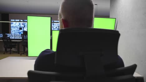 especialista en seguridad de sistemas que trabaja en el centro de control de sistemas. la habitación está llena de pantallas verdes, pantallas cromáticas y seguridad