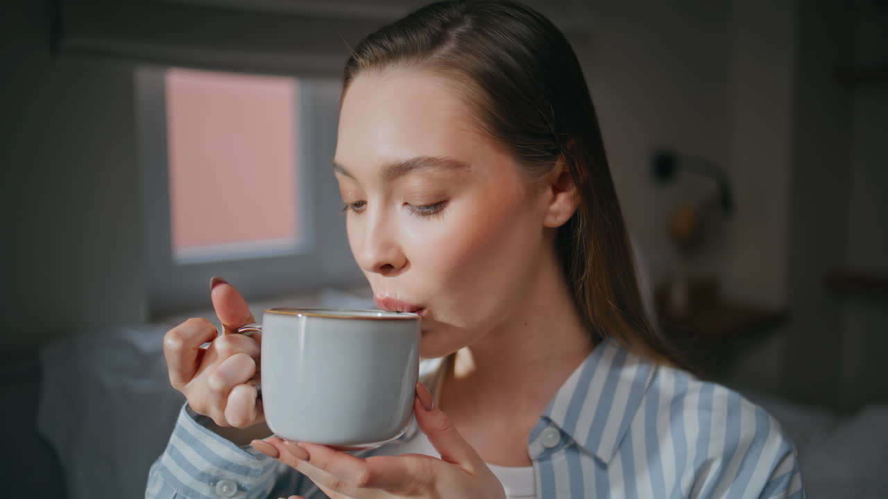 Lady drinking morning coffee in apartment bedroom closeup. Portrait serene woman
