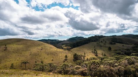 wide shot timelapse of clouds moving in green landscape