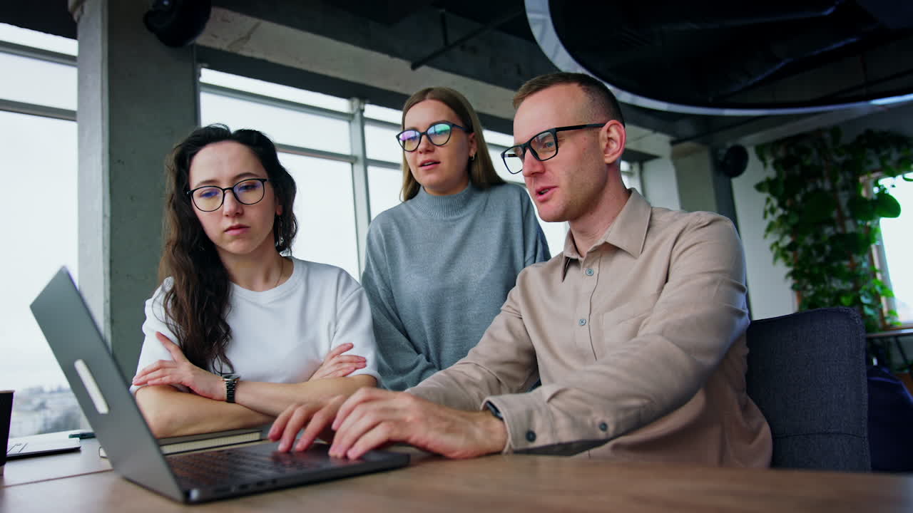 Teamwork on the project. Three colleagues look at laptop and discuss ideas. Creativity concept. Low angle view.