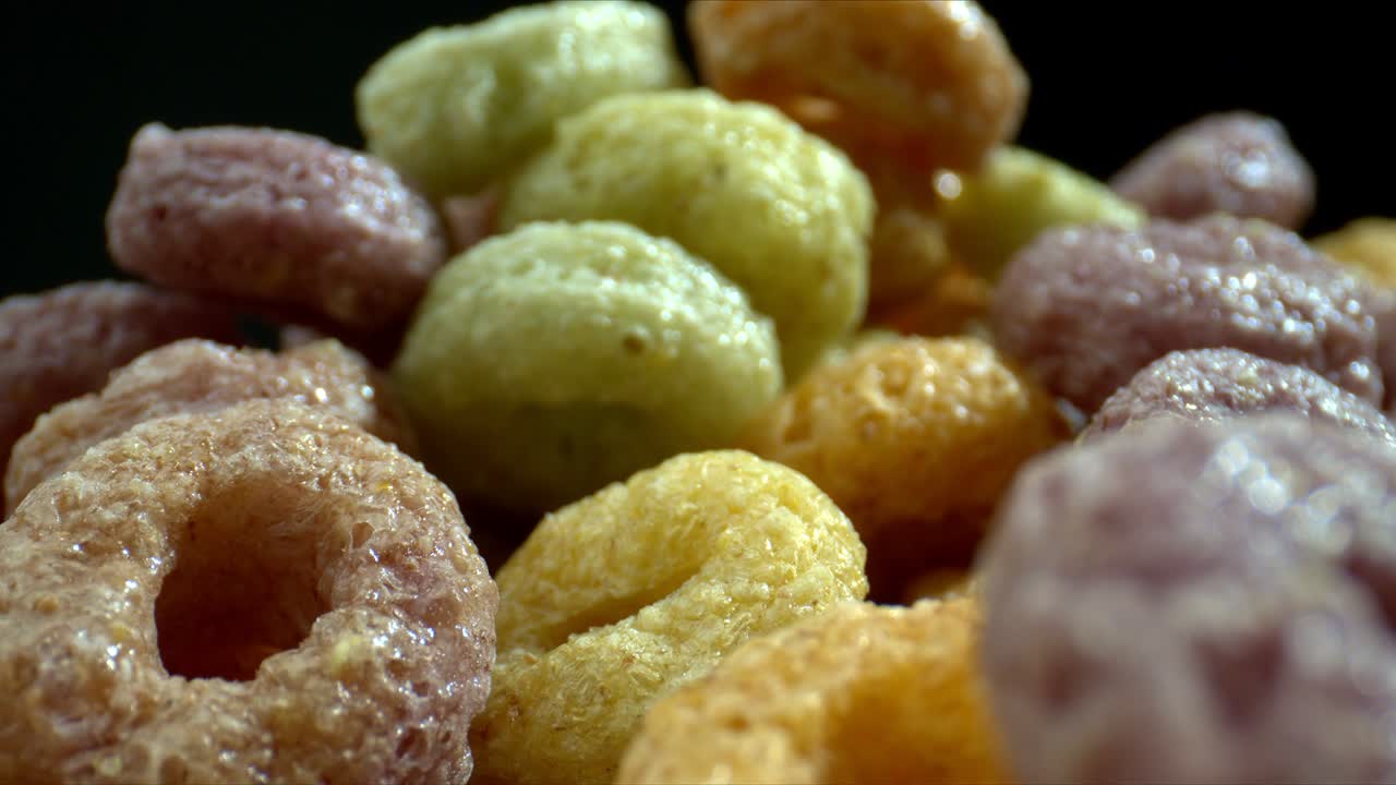 coloridos aros de cereales tiro de diapositivas. cerca de tiro de rotación saludable multicolor