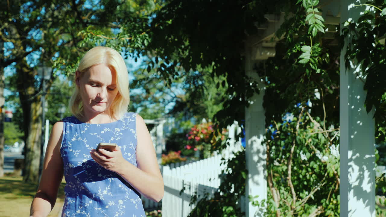 흰색 말뚝 울타리에 의해 가방을 가진 여자