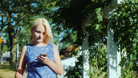 woman with suitcase by white picket fence