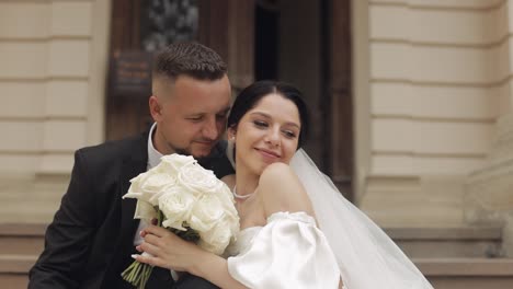 newlyweds portrait, caucasian groom bride walking, embracing, hugs near old castle, wedding couple