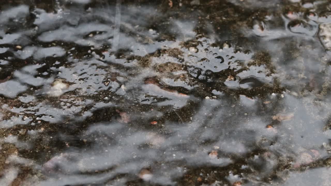 gotas de lluvia rebotando desde el suelo de hormigón enfoque selectivo de fondo de primer plano