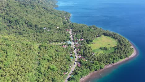 aerial view of countryside road surrounded by lush vegetation on a tropical island in the philippines - drone shot