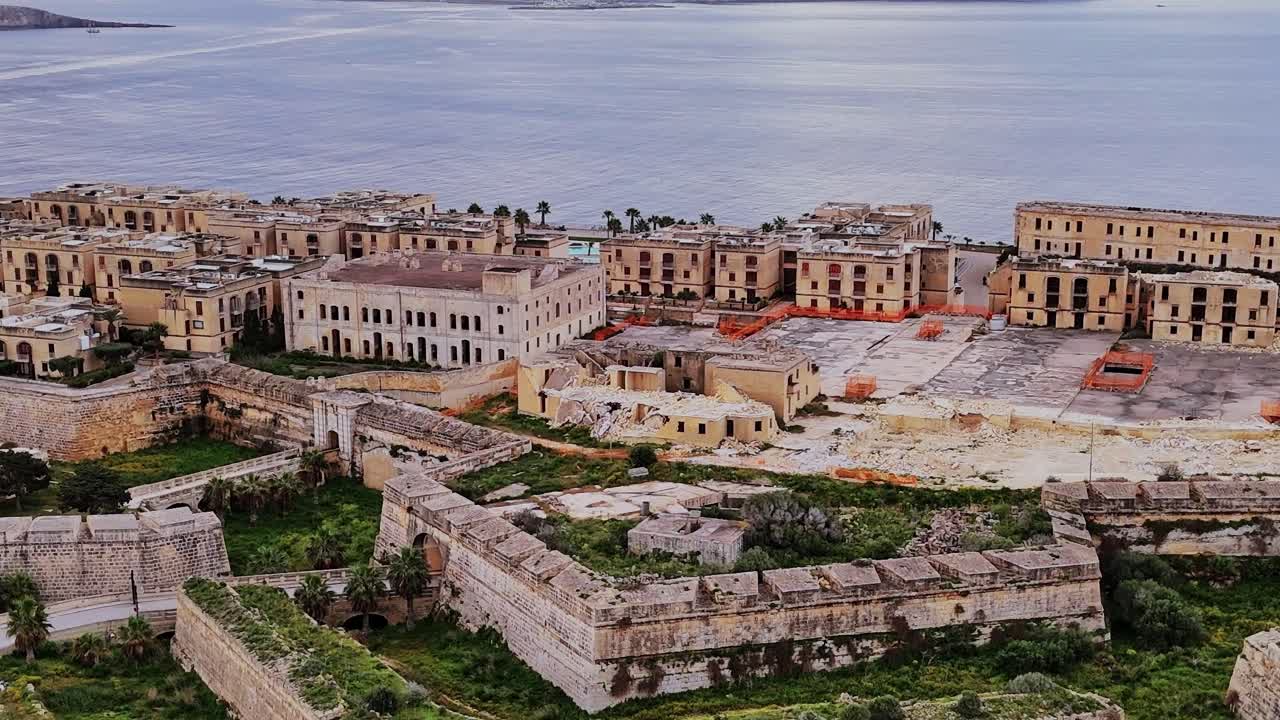 Malta'da gündüz vakti restorasyon çalışması yapılan binalar ve sahil manzarası