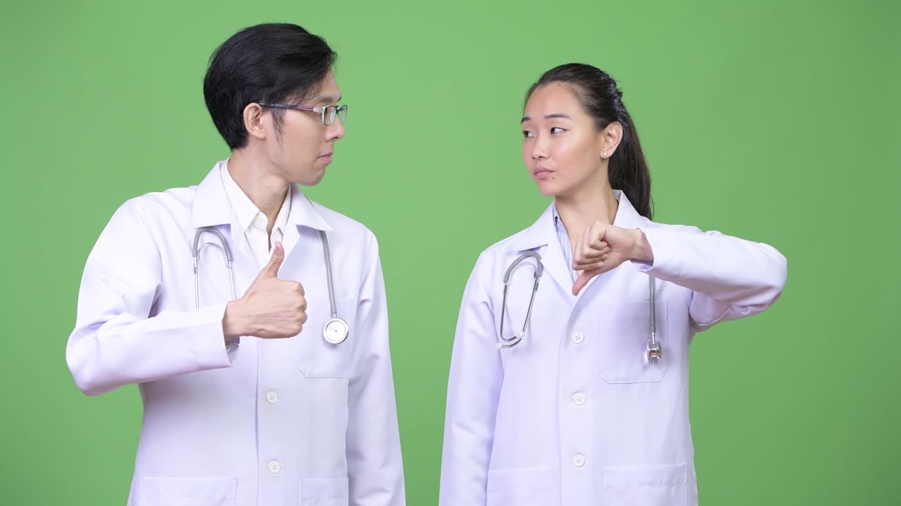 Young Asian couple doctors having different decisions together
