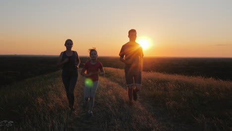 a young child with a couple jogging outdoors in scenic location on the sunset