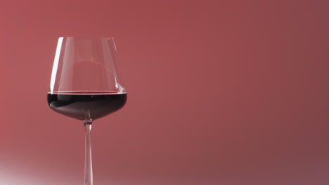 glass of red wine standing over marsala background with copy space