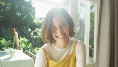 portrait of smiling caucasian woman with brown hair at home on sunny day