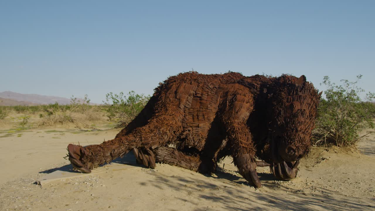 estatua de un armadillo tendido en la arena en el medio del desierto en un día soleado