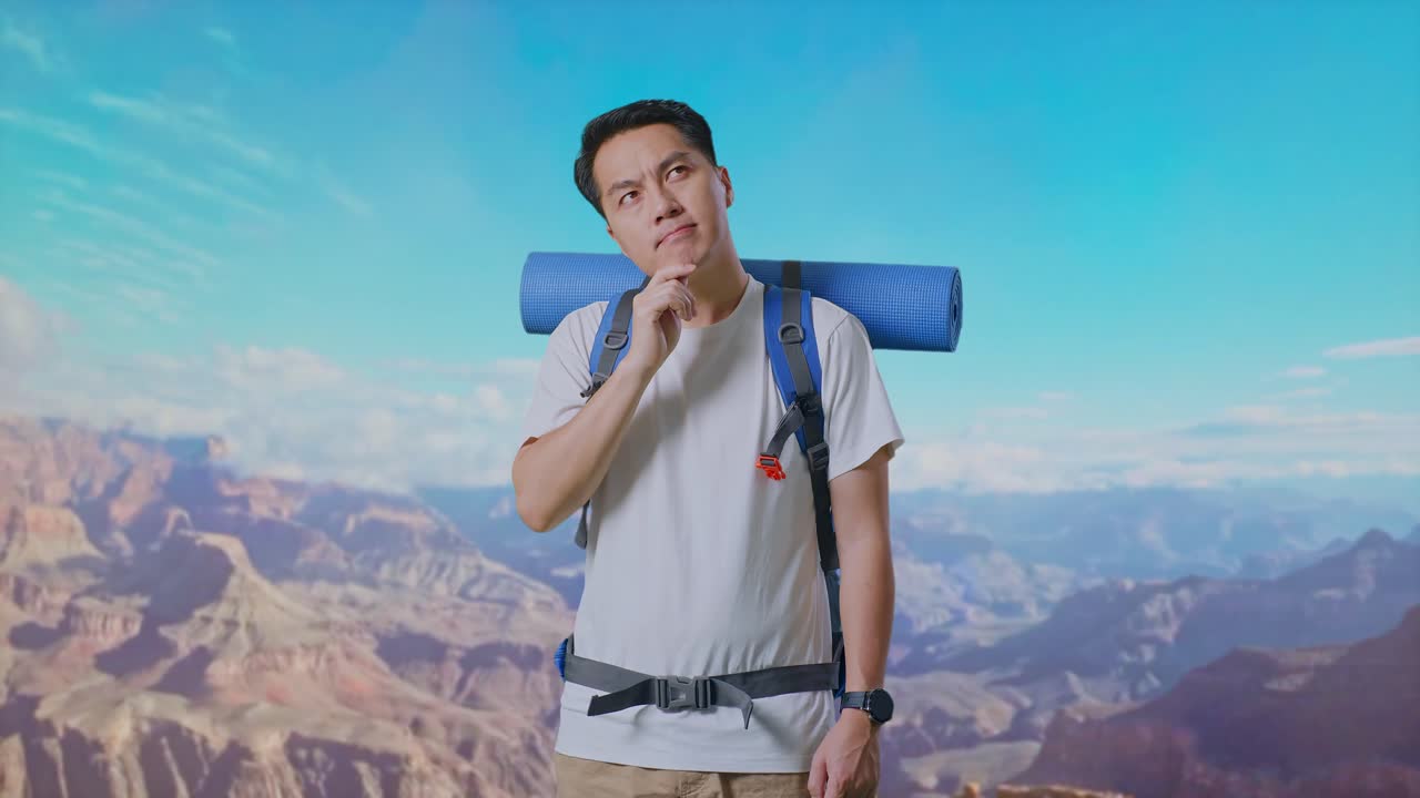 Asian Male Hiker With Mountaineering Backpack Thinking About Something And Looking Around Then Raising His Index Finger While Traveling At The Top Of Mountain