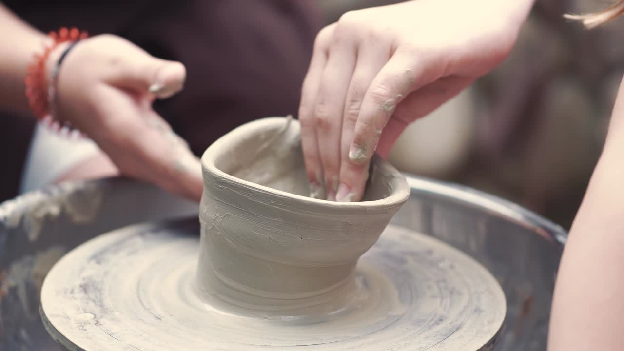 Close up hands make pitchers in pottery