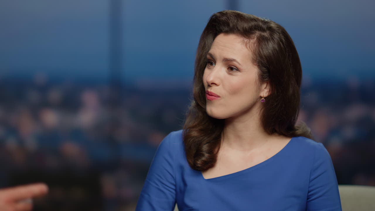 el anfitrión sonriente de primer plano hablando con un invitado masculino en un programa de entrevistas en vivo de primer plano.