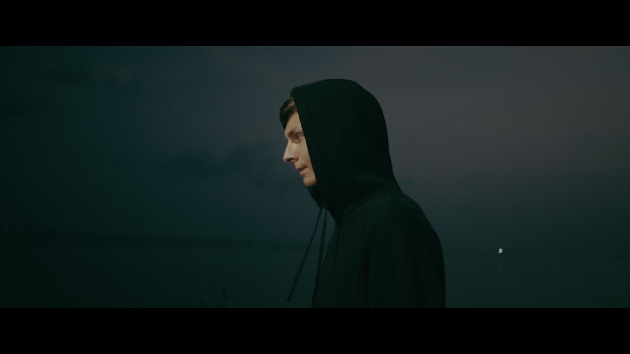 Person in Hoodie at Dusk by the Sea