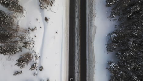 Aerial-top-down-shot-of-cars-driving-down-a-road-in-the-Colorado-Rockies