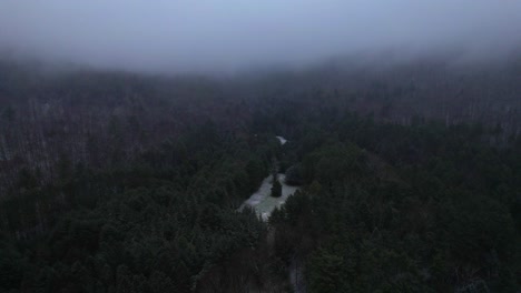 Aerial-drone-video-footage-of-a-beautiful-snowy,-foggy-evening-with-low-clouds-in-the-Appalachian-mountains-during-winter