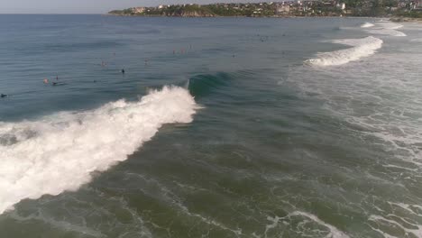 Aerial-drone-shot-of-a-surfer-surfing-a-tube-barrel-wave-and-falling-in-Zicatela-beach-Puerto-Escondido,-Oaxaca